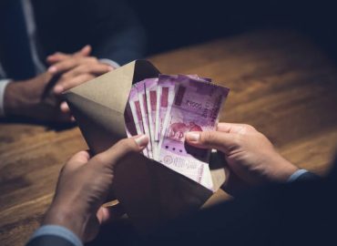 Businessman counting money, Indian Rupee currency, in the envelope just given by his partner after making an agreement in private dark room - loan, briberry and corruption scam concepts